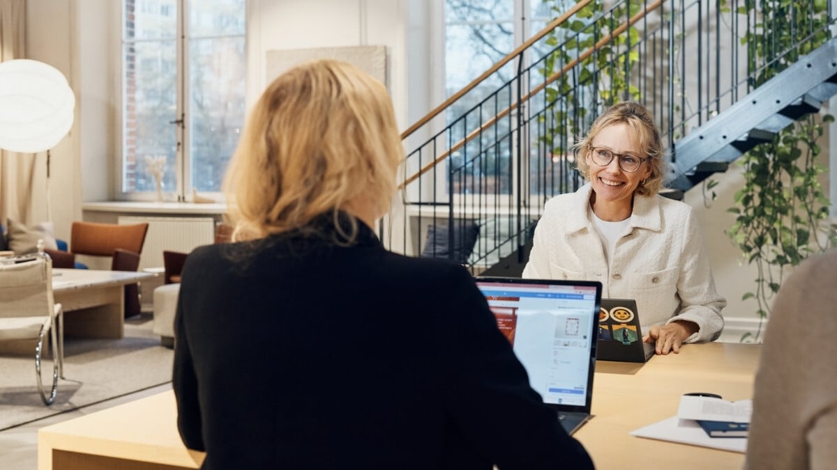 Two female colleagues chatting while working on the computer